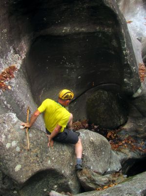 John makes his way carefully down the blockage fish rock to get back to the bottom of the slot canyon 
